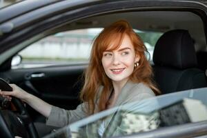 schattig jong dame gelukkig het rijden auto. beeld van mooi jong vrouw het rijden een auto en lachend. portret van gelukkig vrouw bestuurder stuurinrichting auto met veiligheid riem foto