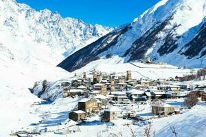 klein dorp in winter met Kaukasus berg. ushguli beroemd mijlpaal in svaneti Georgië is een van de hoogste nederzettingen in Europa. foto