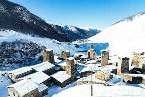 klein dorp in winter met Kaukasus berg. ushguli beroemd mijlpaal in svaneti Georgië is een van de hoogste nederzettingen in Europa. foto