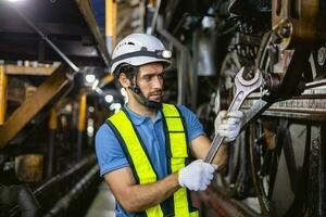 arbeider werken in industrieel fabriek toepassingen een kruis schroevedraaier naar inspecteren de machine. foto