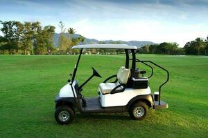 nieuw wit golf kar geparkeerd Aan golf Cursus gras foto