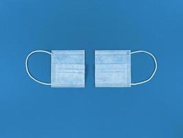 medisch wegwerp gezichtsmasker in tweeën gesneden op een blauwe achtergrond foto