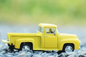 vervagen geel vrachtwagenspeelgoed met groene bokeh lichte achtergronden foto