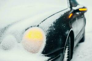 auto onder sneeuw met risico waarschuwing lichten Aan - noodgeval hou op in ijzig weer in moeilijk weer voorwaarden foto