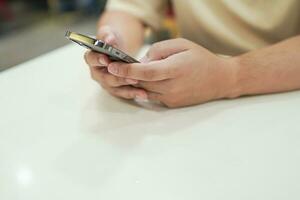 ontspannen jong Aziatisch Mens gebruik makend van slim telefoon uitgeven tijd controle nieuws sociaal media. foto