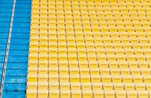 leeg geel stoelen Bij stadion, rijen loopbrug van stoel Aan een voetbal stadion foto