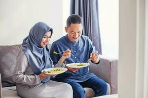 mooi zuidoosten Aziatisch paar aan het eten samen vieren eid al fitr of eid al adha foto