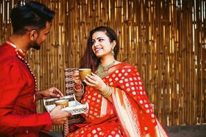 Indisch man portie thee naar zijn zwanger vrouw in een Saree foto