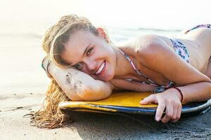 vrouw aan het liegen Aan surfboard foto