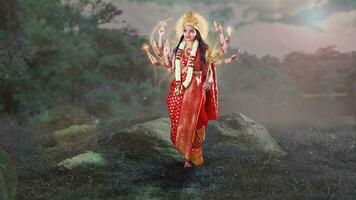 Indisch godin durga met acht handen staand in de buurt de meer in rood Saree foto