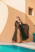 mooi bevallig Kaukasisch vrouw vervelend abaya met de kleding stof streaming met een wind foto