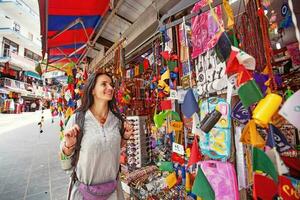 Kaukasisch vrouw net zo een toerist wandelen in een traditioneel souvenir markt in dharamsala, Indië foto