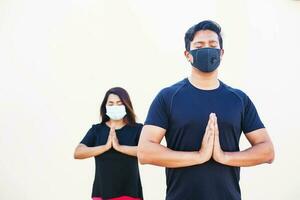 knap Indisch Mens aan het doen yoga opdrachten en meditatie in gezicht masker foto