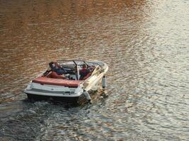 een luxe motorboot staat Aan de water Bij zonsondergang. kom tot rust in een motor boot. foto