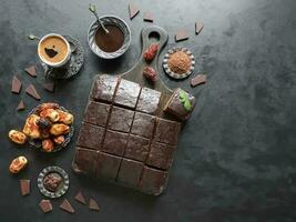chocola brownie taart met zwart koffie, toetje Aan zwart achtergrond foto