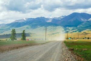 stof storm over- de weg in de platteland tegen de achtergrond van bergen. foto