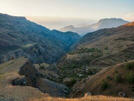 kleurrijk zonsondergang landschap met silhouetten van groot rotsachtig bergen en episch diep kloof in dagestan. foto