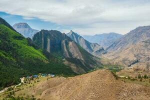 pittoreske berg vallei in dagestan. kleurrijk zonnig groen landschap met rivier- en silhouetten van groot rotsachtig bergen en episch diep kloof. foto