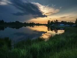 zonsondergang over- de rivier. pudost dorp. Rusland foto