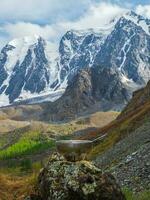 leeg toerist kom met een lepel is gelegd uit Aan een steen tegen de achtergrond van een gletsjer en hoog bergen. lunch tijd, grote hoogte trekking. foto