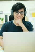 jonge man studeert thuis achter de laptopcomputer foto