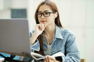 jong vrouw studie in voorkant van de laptop computer Bij huis. foto