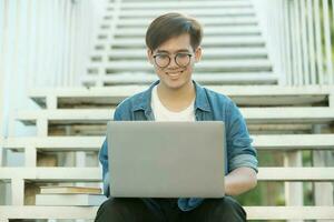 leerling aan het studeren buitenshuis gebruik makend van laptop. foto