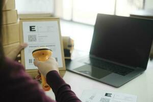vrouw online bedrijf eigenaar scannen Verzending etiket Aan perceel. foto