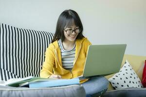 jong collage leerling gebruik makend van computer en mobiel apparaat aan het studeren online. foto