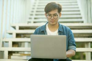 leerling aan het studeren buitenshuis gebruik makend van laptop. foto