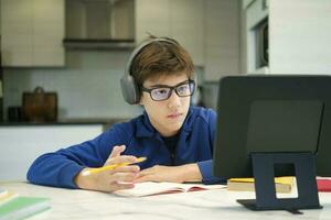 leerling jongen met tablet computer aan het leren Bij huis foto