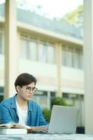 leerling aan het studeren buitenshuis gebruik makend van laptop. foto