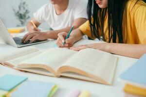 dichtbij omhoog een Aziatisch studenten zijn lezing boeken en studie, bijles samen. foto