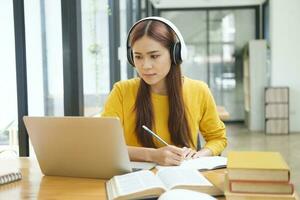 vrouw aan het leren online gebruik makend van laptop en schrijven notities. foto