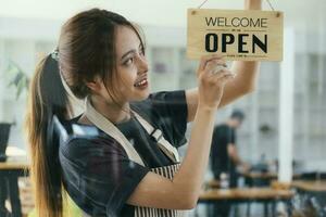 jong bedrijf eigenaar Open de koffie winkel. foto