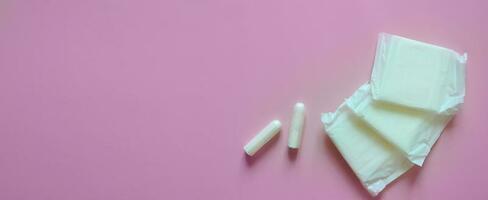 tampons en stootkussens Aan een roze achtergrond, intiem hygiëne, vrouwen hygiëne, menstruatie en kritiek dagen, vrouwen Gezondheid, banier foto