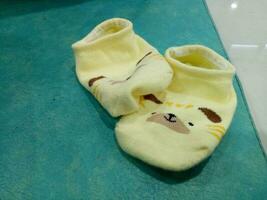 schattig baby sokken in geel en een Guinea varken gezicht foto