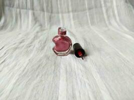 een roze nagel Pools met een uniek voor de helft hart vormig fles foto