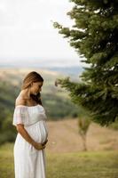jonge zwangere vrouw op het veld