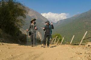 een jong paar reizigers trekking in poon heuvel visie punt in ghorepani, Nepal foto