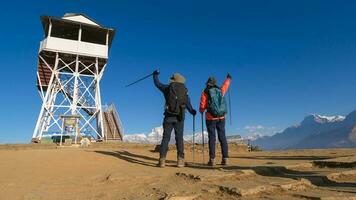 een jong paar reizigers trekking in poon heuvel visie punt in ghorepani, Nepal foto