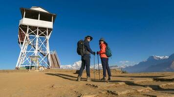 een jong paar reizigers trekking in poon heuvel visie punt in ghorepani, Nepal foto