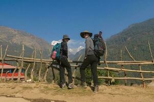 een jong paar reizigers trekking in poon heuvel visie punt in ghorepani, Nepal foto