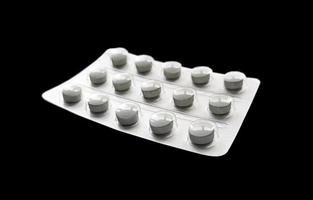 grijze pillen in blister geïsoleerd op zwarte achtergrond foto