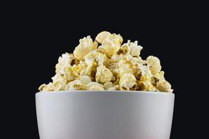 close-up van paddestoel popcorn in een witte kom met zwarte achtergrond foto