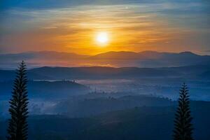 berg reeks met zichtbaar silhouetten door de ochtend- kleurrijk mist foto