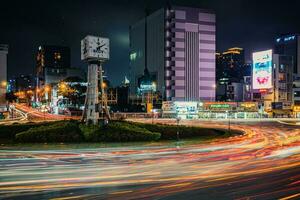 ho chi minh stad, Vietnam - apr 14, 2023 verkeer jam Bij dien bien phu rotonde met haar vier gezichten klok toren een symbool van ho chi minh stad. licht spoor van auto's. foto