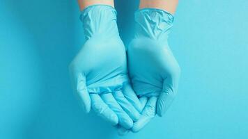 leeg twee hand- met handschoenen aan het doen teken voor helpen Aan blauw achtergrond. foto