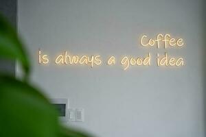 een geel neon teken Aan wit muur Bij koffie winkel. foto