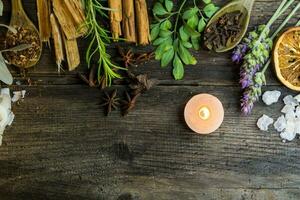 verscheidenheid van bloemen, kruiden, kaarsen en essenties voor aromatherapie, Aan rustiek hout foto
